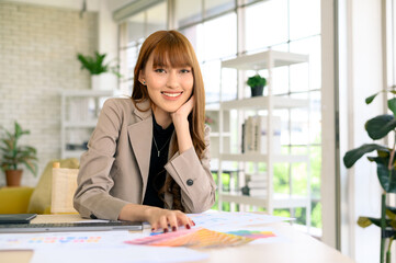 Young Asian Women graphic designer working with diagrams color and computer graphic at office.