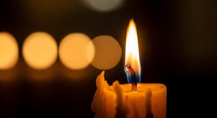 Illuminated candle flame with bokeh background creates serene ambiance