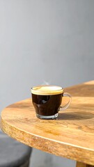 A steaming cup of espresso on a wooden table