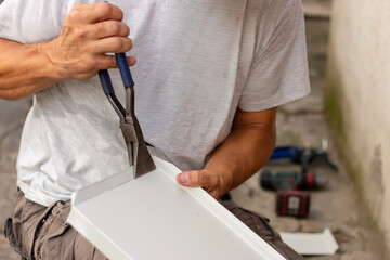 Naklejka premium A craftsman preparing metal sill for external PVC window frame. The process of preparing and cutting window sills. Home improvement, DIY concept.