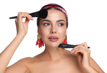 Beautiful woman with makeup brushes on white background