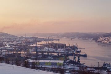 Fototapeta premium View of the Murmansk seaport from the Green Cape hill. Low sun during the polar night.