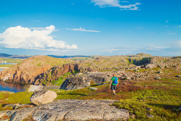 A male tourist in the Teriberka Nature Park on the shore of the Barents Sea.