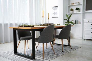 Decorated wooden table with chairs in dining room