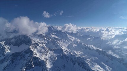 Aerial View of Majestic Snow-Capped Mountains Under Clear Sky