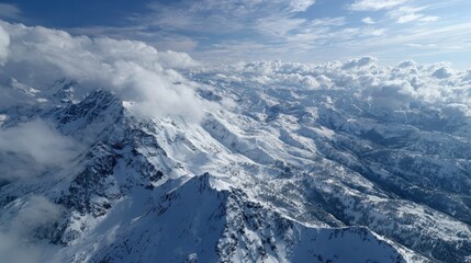 Expansive Snowy Mountain Range Under Bright Blue Sky with Clouds