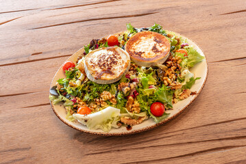 Warm melted goat cheese salad on an oak leaf lettuce bed, roasted cherry tomatoes, and crispy rye bread croutons
