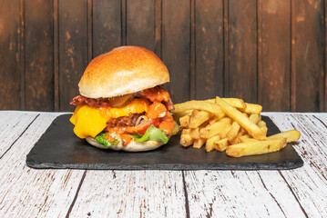 Close-up of cheese melting over beef in a burger with brioche bun, accompanied by crunchy pickles