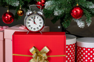 Alarm clock and gift boxes under christmas tree. Christmas background