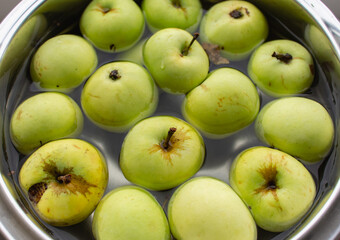 Fresh green apples in bowl. Ripe apples in water. Autumn harvest. Organic fruits background. Heap of green apples. Raw dieting. Natural vitamin. Healthy eating concept. Natural snack.