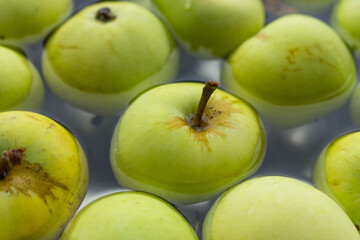 Fresh green apples in bowl. Ripe apples in water. Autumn harvest. Organic fruits background. Heap of green apples. Raw dieting. Natural vitamin. Healthy eating concept. Natural snack.