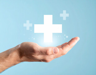 Hand Holding White Plus Sign on Light Blue Background, Health Concept.