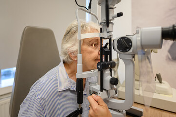 Senior woman undergoing eye examination with slit lamp for clear vision checkup at ophthalmology clinic