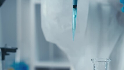In a lab, a skilled scientist uses a pipette to manage a vibrant blue liquid, highlighting the necessity of precision and accuracy in scientific research and innovation for advancing various fields