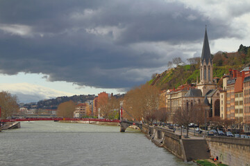 River, pedestrian bridge, embankment and church. Lyon, France