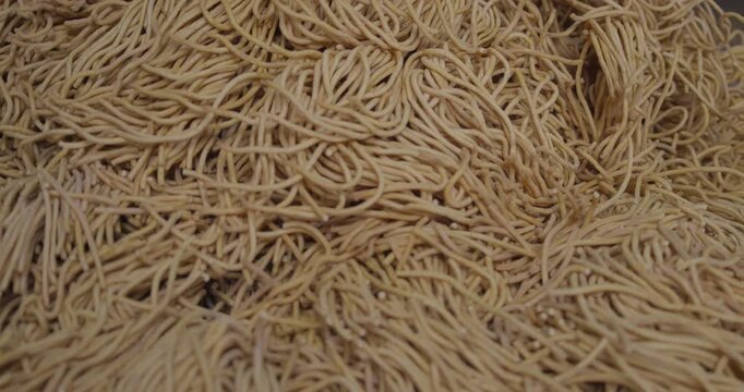Close-up cinematic shot of deep-fried sev and Indian junk food being cooked in hot oil, showcasing crispy texture and street food culture