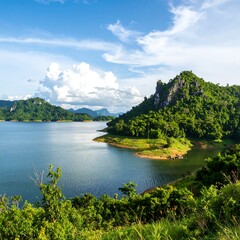 Scenic lake nestled in lush, forested hills under a vibrant blue sky