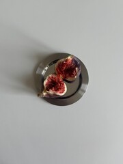 fig cut in half on a plate  on a white background