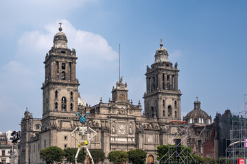 Obraz premium The two tall buildings are very old and have a lot of detail on them. The sky is clear and blue. Day of the Dead celebration in Mexico, papel picado crafts, offerings, La Catrina