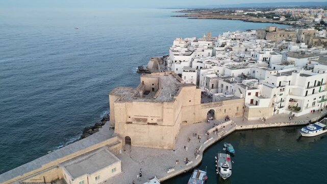 Aerial drone flight above Monopoli harbour, fortress and old city. Footage taken on June 22, 2025, in Monopoli, Apulia, Italy.
