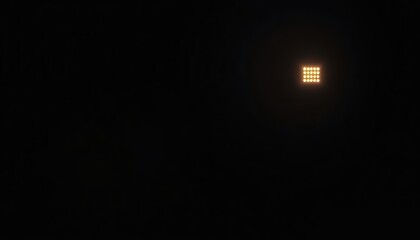A solitary glowing window illuminates the deep blackness of the night, creating a minimalist and abstract background with ample copy space