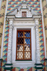 A beautiful window with bright columns and bas-reliefs on a clear sunny day. Sights of Russia, World tourism.