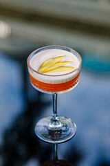 A sophisticated cocktail presented in a clear stemmed glass with garnished fresh fruit. The scene exudes elegance and refinement, perfect for luxury dining, celebrations, or social gatherings.