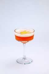 A sophisticated cocktail presented in a clear stemmed glass with garnished fresh fruit. The scene exudes elegance and refinement, perfect for luxury dining, celebrations, or social gatherings.