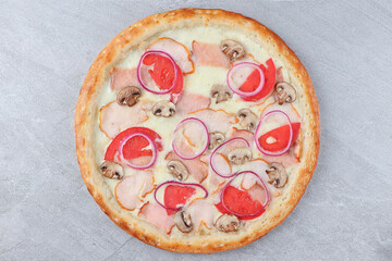 Pizza with Chicken, Mushrooms, Red Onion Rings, Tomato Slices, and Melted Cheese on Gray Stone Background