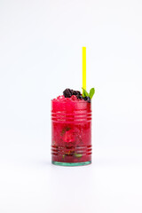 Tropical berry-based beverage featuring crushed ice, lime garnish, and a sprig of mint, served with a yellow straw