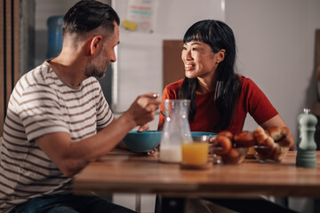 Happy couple enjoying breakfast together at home