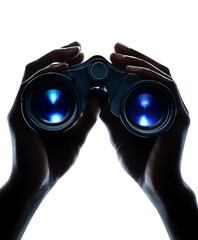 Hands holding binoculars in the dark.