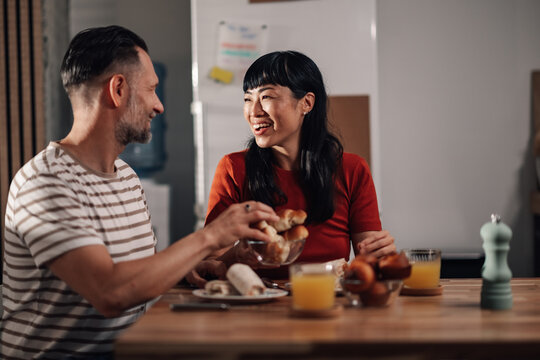Happy couple enjoying breakfast together in modern kitchen - Powered by Adobe