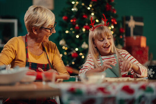 Grandmother and granddaughter making christmas cookies at home - Powered by Adobe