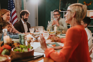 Family celebrating thanksgiving dinner with american flag in background
