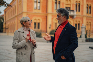 Senior couple talking while walking in urban setting