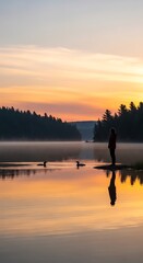 Fototapeta premium Silhouette of a person observing birds at sunrise over a tranquil lake, with reflections in the still water.
