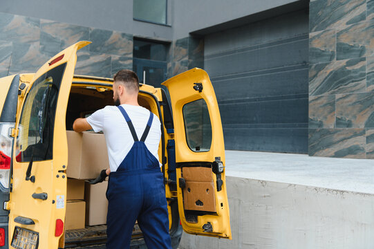 Courier loading cardboard boxes into delivery van