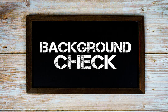 Background Check text written on blackboard flat lay on wooden background