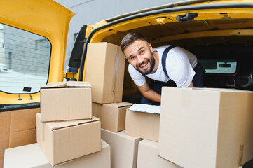 Delivery courier checking cardboard boxes in van