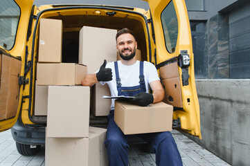 Deliveryman sitting in van with packages giving thumbs up