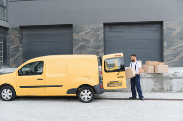 Delivery driver unloading cardboard boxes from yellow van
