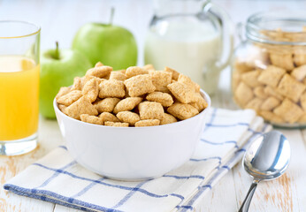 Breakfast for kids with corn pillows and and fruits and juice on a light kitchen table, selective focus. Healthy corn pillows with milk for Breakfast with fruit.