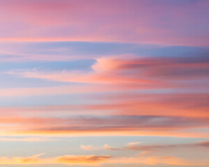 Obraz premium Dramatic Sky Painting a Canvas of Soft Pink and Orange Hues During Sunset or Sunrise, Creating a Tranquil Atmosphere