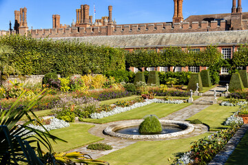 Colourful sunken pond gardens and Tudor facade of the Palace in summer