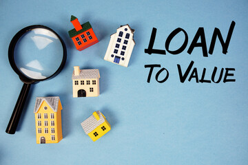 LTV Loan To Value text with house models and magnifying glass on blue background