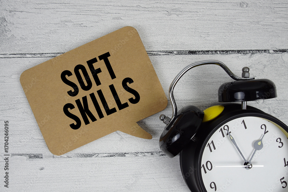Poster soft skills text with alarm clock on wooden background