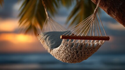 Obraz premium A serene hammock hangs between palm trees, set against a beautiful sunset backdrop, perfect for relaxation and leisure.