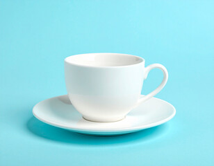 Obraz premium Minimalist White Cup and Saucer on Light Blue Background, Studio Shot
