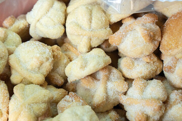 A bag of sugar cookies with a white frosting. The cookies are small and round. They are covered in sugar. Day of the Dead celebration in Mexico, papel picado crafts, offerings, La Catrina